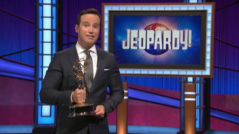 Mike Richards accepting an Emmy award for Jeopardy! in 2021, smiling and holding the Emmy statuette.