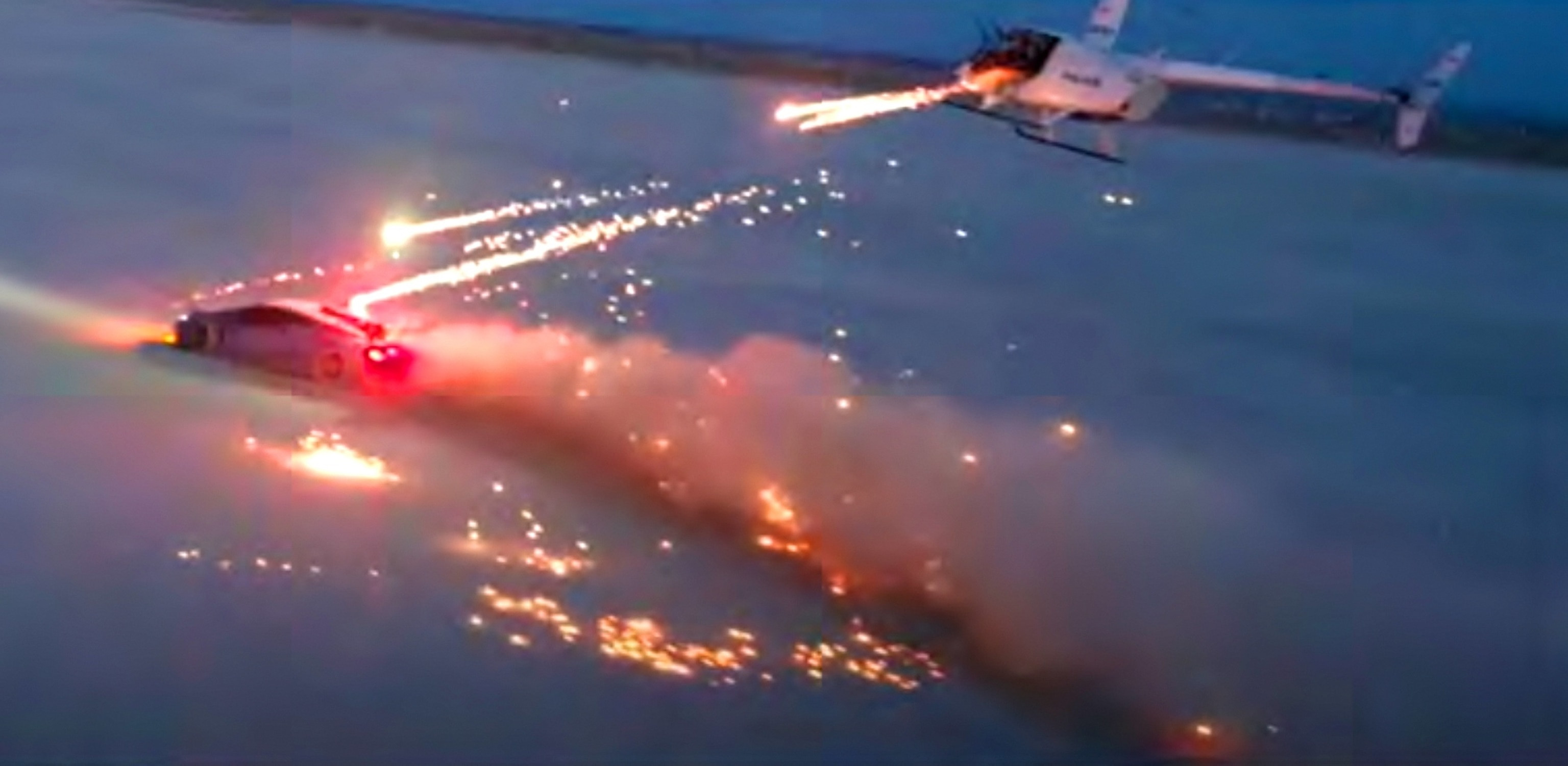 Still from the "Destroying a Lamborghini with Fireworks" video showing fireworks being launched from a helicopter towards a red Lamborghini, part of the evidence against YouTuber Alex Choi.