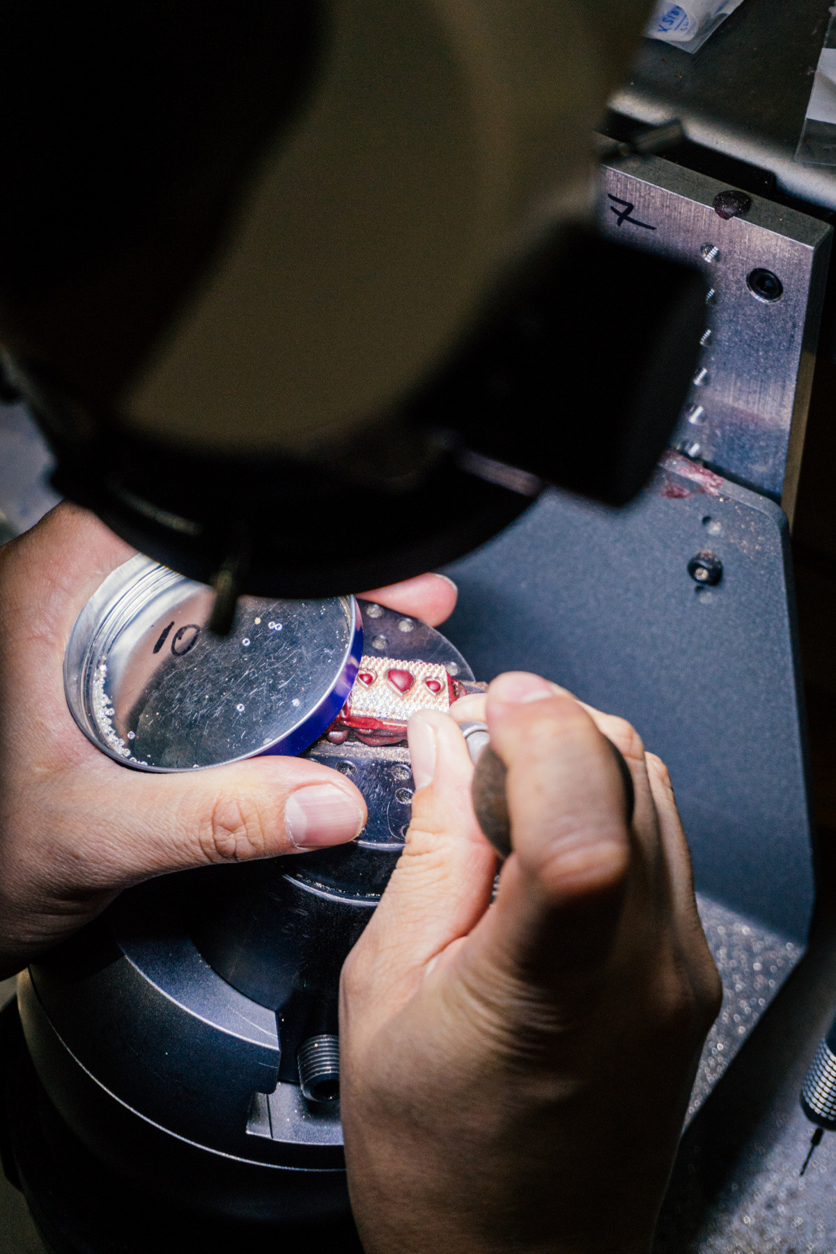 alt text: Alex Moss in his workshop observing the jewelry making process.