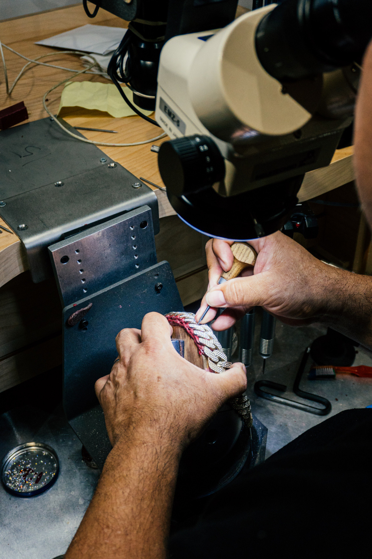 alt text: Jeweler Alex Moss examining a piece of jewelry.